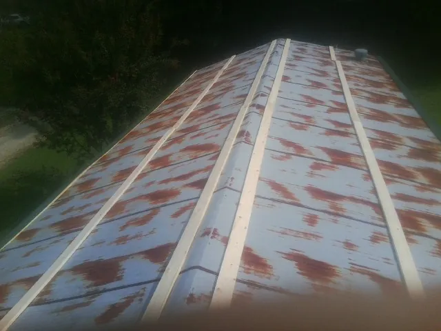 Rusted metal roof panels with new wood purlins before replacement — Storm Damage Roof Repair in Skillman by Roofing Brothers