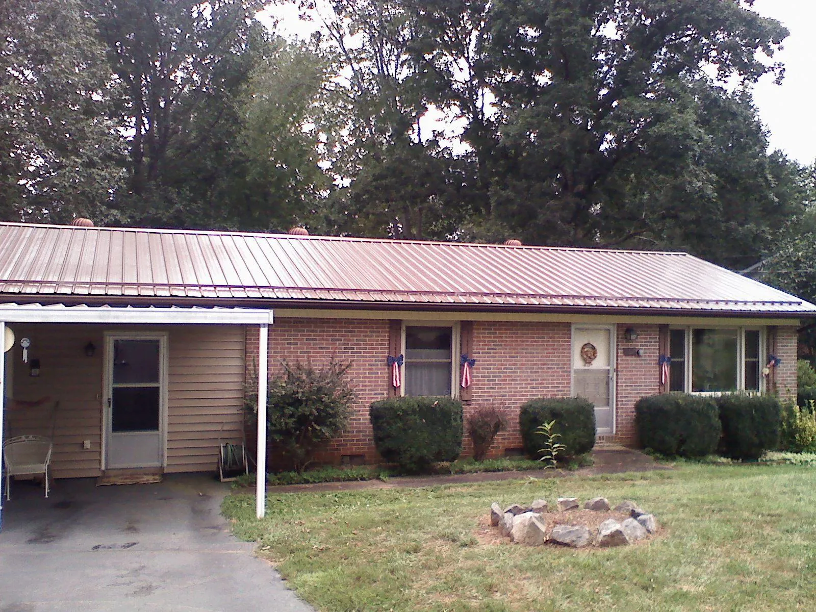 Bronze metal roof and carport on a brick ranch home — Roof Repair work by our crew in Skillman